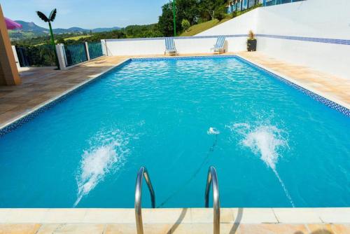 a swimming pool with dolphins in the water at Casa de campo 2qtos região de Extrema in Extrema