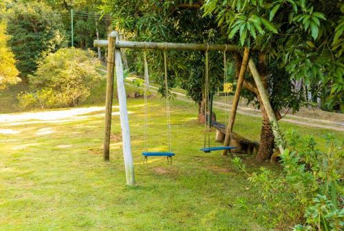 two swings in a park with a tree at Casa de campo 2qtos região de Extrema in Extrema