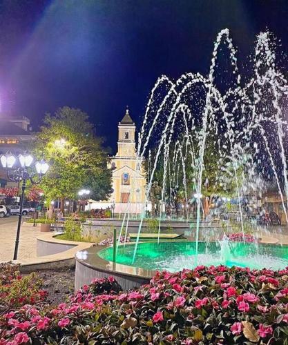 a fountain in front of a clock tower at night at Casa de campo 2qtos região de Extrema in Extrema