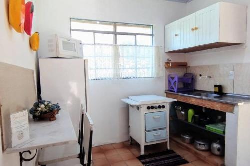a small kitchen with a refrigerator and a microwave at Casa de campo 2qtos região de Extrema in Extrema