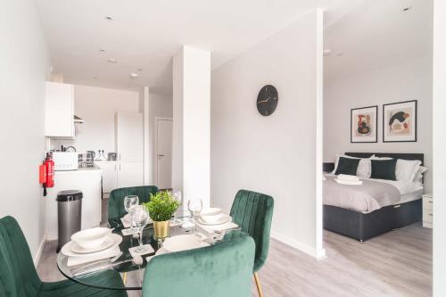 a dining room with a table and green chairs at Stylish 2 Bed Apartment in Waterloo Liverpool in Liverpool