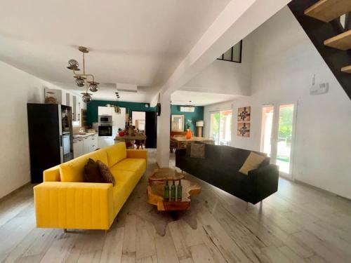 a living room with a yellow couch and a table at Le Mas Victoria - Chambres d'hôtes avec table d'hôtes-Parking privé ferme in Carcassonne