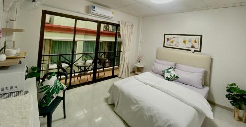 a bedroom with a bed and a balcony at Patong Rest & Recharge in Patong Beach