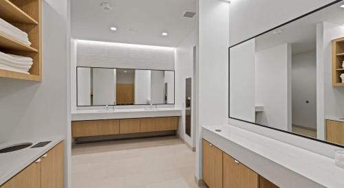 a bathroom with white walls and a large mirror at High-Rise Apt Raleigh Free Parking & Sunset View 1 in Raleigh