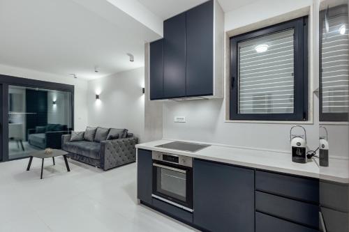a kitchen with black cabinets and a living room at Savina Bliss Residences in Herceg-Novi