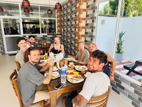 um grupo de pessoas sentadas à mesa comendo comida em iResort em Weligama