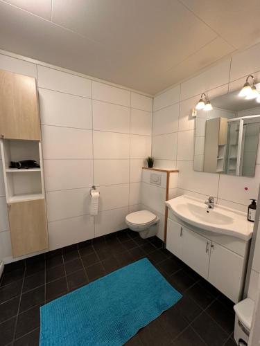 a bathroom with a sink and a toilet and a mirror at 2 bedrooms apartment in Tønsvika in Tromsø