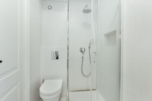 a white bathroom with a toilet and a shower at Savina Bliss Residences in Herceg-Novi