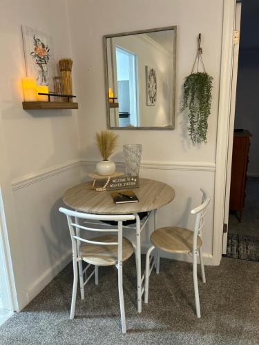 a dining room table with two chairs and a mirror at Your Weaver Rest Stop on the Ladiga Trail! in Weaver