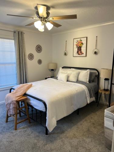 a bedroom with a large bed with a ceiling fan at Your Weaver Rest Stop on the Ladiga Trail! in Weaver