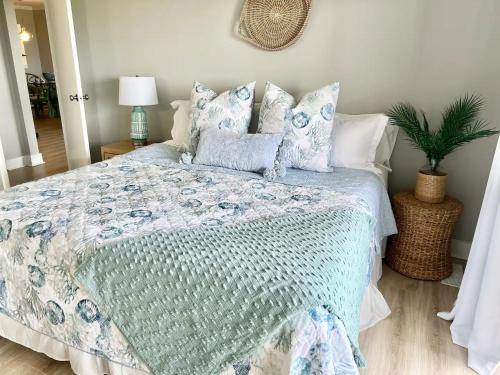 a bedroom with a bed with blue and white pillows at The Salty Breeze - Ocean Front 1 Bedroom in St. Helena Island