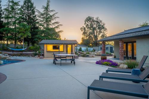 a patio with a picnic table and a building at Casteel - 4,500 sq-ft retreat with a pool and hot tub in the middle of wine country! in Templeton