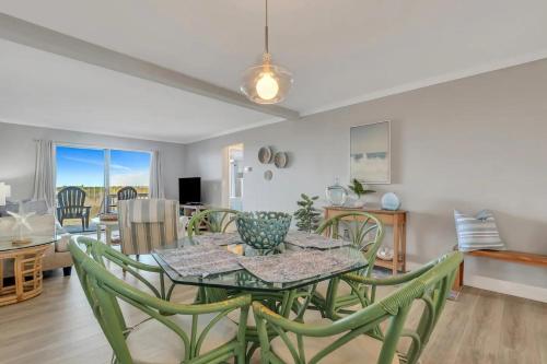 a dining room with a table and some chairs at The Salty Breeze - Ocean Front 1 Bedroom in St. Helena Island