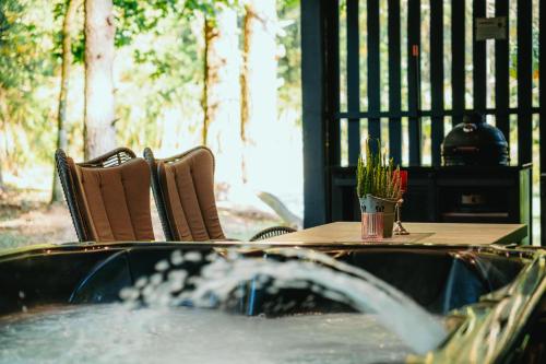 a hot tub with a table and chairs and a fountain at Cocodeno-'Virš Ąžuolų' - Forest SPA - FREE jacuzzi in Paplatelė