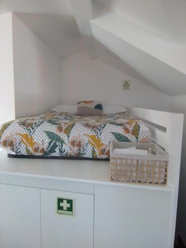a bed sitting on top of a white cabinet at ChezGyKa - Sinta-se Em Casa! in Viseu