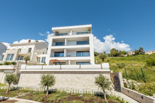 a white apartment building with trees in front of it at Savina Bliss Residences in Herceg-Novi