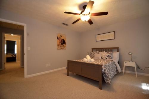 una camera da letto con un letto e un ventilatore a soffitto di The Cozy Pearl Townhome - 10 mins to horse park a Conyers
