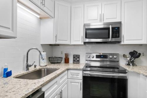 a white kitchen with a sink and a microwave at The Conyers Oasis - 10 mins to horse park in Conyers