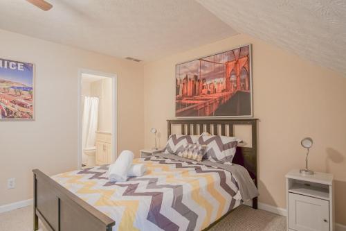 コンヤーズにある2 BR Townhouse - 10 Mins to Horse Parkのベッドと壁に絵が飾られた寝室