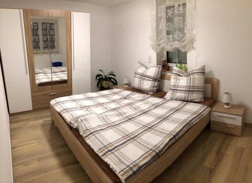 a bedroom with a bed with plaid pillows on it at Erzgebirgsferien in Olbernhau