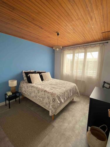 une chambre avec un lit et un plafond en bois dans l'établissement Chez Fanfan à 150m de la mer, à Hauteville-sur-Mer