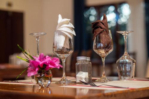 a table with wine glasses and flowers on it at Andasibe Lemurs Lodge in Andasibe