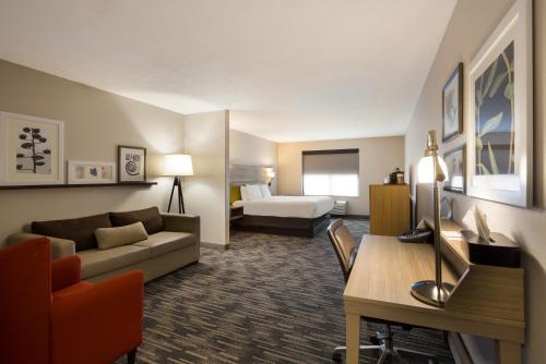 a hotel room with a couch and a bed at Country Inn & Suites by Radisson, Marion, IL in Marion