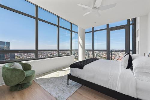 a bedroom with a white bed and large windows at K2 Sky High Apartments with Stunning Chicago Views in West Loop in Chicago