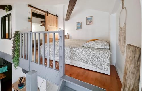 une petite chambre avec un lit et un escalier dans l'établissement Fleuriau cozy boheme Proche marché & Vieux Port, à La Rochelle