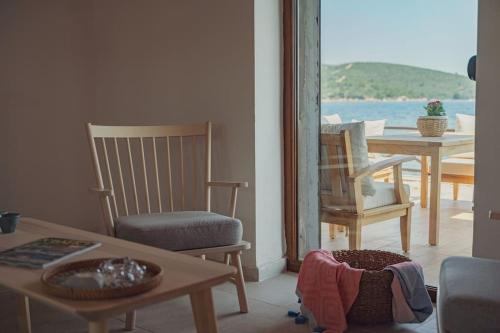a living room with a table and chairs and a view of the ocean at Urla Sunrise House in Ildır