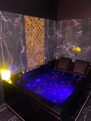 a jacuzzi tub in a room with chairs at Love Instant in Chalon-sur-Saône