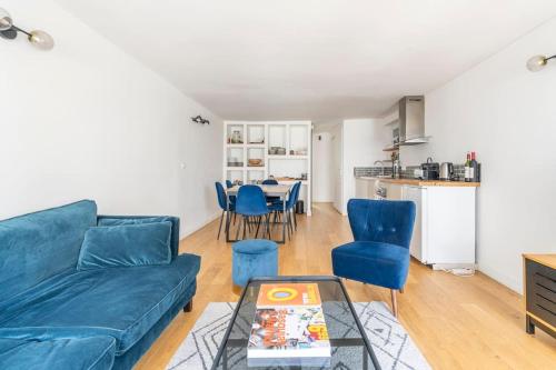 un salon avec un canapé bleu et une table dans l'établissement Apt moderne rénové et spacieux, au cœur de Paris, à Paris