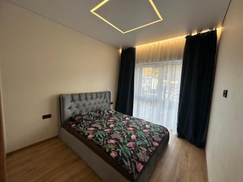 考纳斯Jaukus butas 2 kambariu girioje的一间卧室，床位于窗前