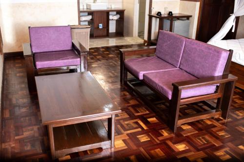 two purple chairs and a couch in a room at Andasibe Lemurs Lodge in Andasibe