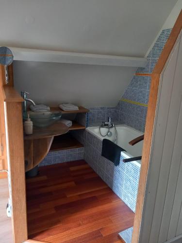 une petite salle de bain avec un lavabo et une baignoire dans l'établissement Cottage du Becquet, à Épaignes