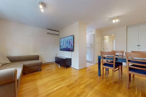 a living room with a couch and a table with chairs at -Air Con- Cute 2BD flat 1 Min Maida Vale Station! in London