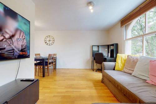 a living room with a couch and a tv at -Air Con- Cute 2BD flat 1 Min Maida Vale Station! in London