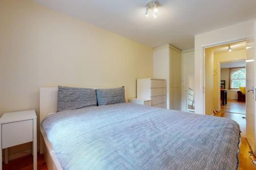 a bedroom with a large bed with blue sheets at -Air Con- Cute 2BD flat 1 Min Maida Vale Station! in London