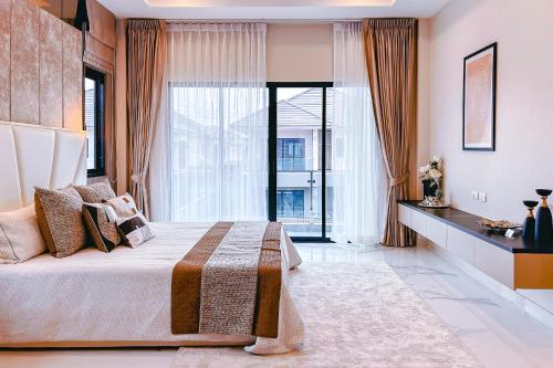a bedroom with a large bed and a large window at Hidden Hill Pool Villa 4BR 15 Mins Jomtien Beach in Ban Huai Yai