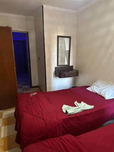 a red bed with two pairs of shoes on it at Hostal oasis in Cairo