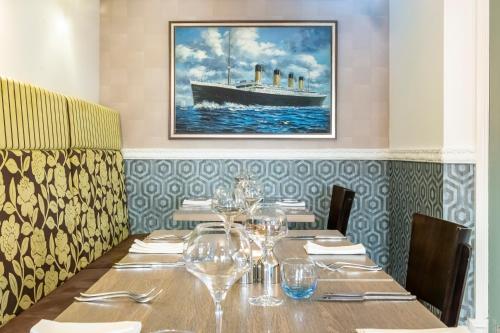 a table in a restaurant with a picture of a boat at Georgian House Hotel in Whitehaven