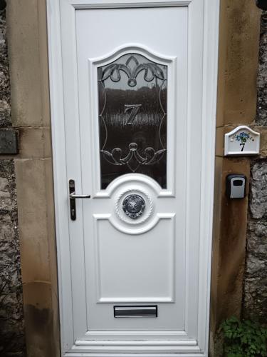 Una puerta blanca con una ventana. en Heatherlea, en Grange-over-Sands