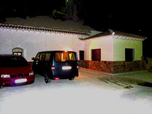 a small car parked in a parking lot in front of a building at Casa-Cueva Las Colleras in Orce