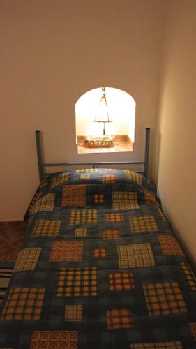 a bedroom with a bed with a quilt on it at Casa-Cueva Las Colleras in Orce