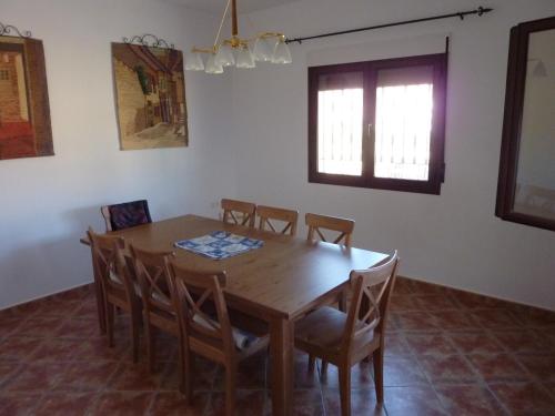 a dining room with a wooden table and chairs at Casa-Cueva Las Colleras in Orce