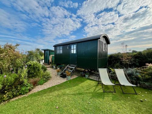 un container verde con due sedie in un cortile di Corner House a Cudworth