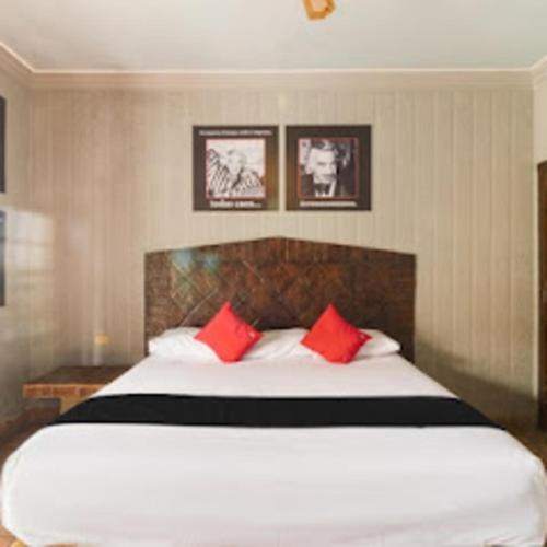 a bedroom with a large white bed with red pillows at Hotel Olimpia Centro Histórico in Monclova