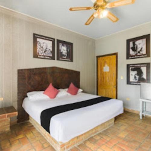 a bedroom with a large white bed with red pillows at Hotel Olimpia Centro Histórico in Monclova