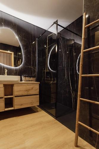a bathroom with a black tiled wall and a ladder at Coruja’s House AL OPO in Porto