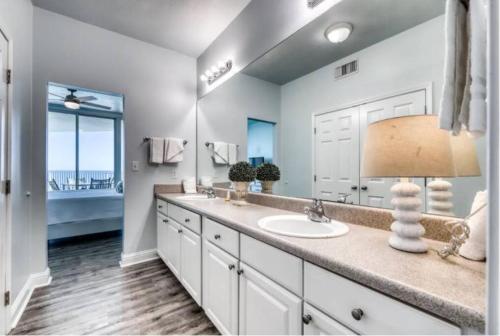 a bathroom with a sink and a large mirror at Lighthouse 1115 Condo on the beach 3BR 3BA in Gulf Shores